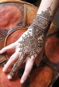 Kvinnlig hand på baksidan av den svarta linjen kreativa vanilj vackra armband tatuering bild