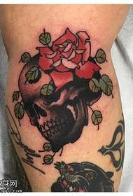 Modello di tatuaggio rosa con teschio piegato sulla gamba