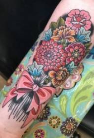 Tatuaggio a braccio piccolo per ragazza con motivo floreale a fiori colorati su motivo a fiocco e fiori colorati