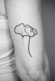 Meitenes roka uz melnas līnijas radoša literārā ginkgo lapu tetovējuma attēla