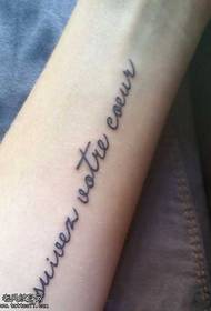 un llarg i petit patró de tatuatge anglès al braç