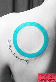 Spalle di bella donna con un modello di tatuaggio cerchio e lettera