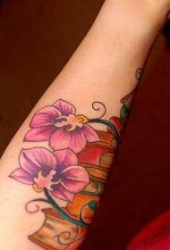 Orkidea tatuaje morea duen emakumezkoen besoa