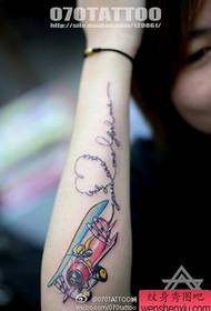 Vajzë e bukur me krah duke parë aeroplanin me modelin e tatuazheve me shkronja