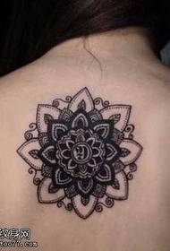 Izsmalcināts ziedu totēma tetovējums mugurpusē
