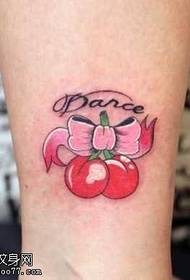 Ben med populært tatoveringsmønster for bue og kirsebær