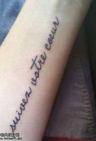 a long, small English tattoo pattern on the arm