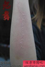 Uzorak tetovaže bijelog slova s jednom rukom