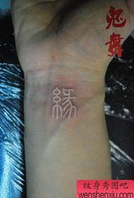 klasisks balts ķīniešu tetovējuma raksts uz rokas