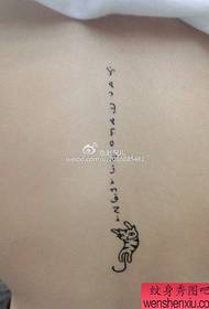 Small and beautiful letter tattoo on the back of the girl