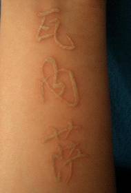 Hvid kinesisk tatoveringsbillede på armen