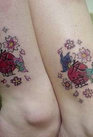 female leg Japanese style symbol with flower tattoo