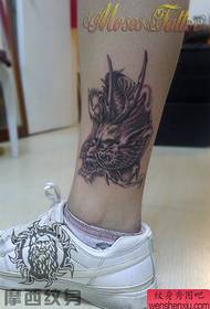 le gambe della ragazza sembrano un bel modello di tatuaggio del drago grigio nero