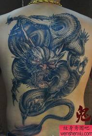 un motif dominateur de tatouage de dragon dans le dos que les garçons aiment