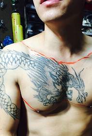 tatuanu di dragone neru è biancu sopra à a spalla