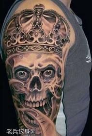 bras portant une couronne avec un motif de tatouage