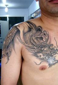 um excelente dragão xale no peito sobre o padrão de tatuagem no ombro do dragão