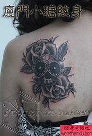 spalle della ragazza bellissimo teschio bianco e nero e motivo tatuaggio rosa