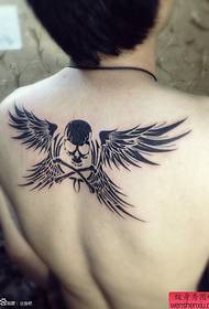 Enrere funciona un tatuatge de ales amb crani totem