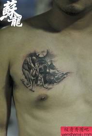 ny tratrany eo alohan'ny lehilahy iray vita amin'ny tatoazy anjely mipetraka ao amin'ny fasana