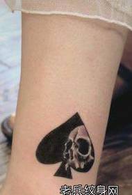 a girl's leg with a spade and a tattoo pattern