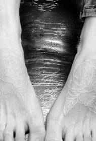 足の甲に美しい白い目に見えない花のタトゥーパターン