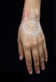 mergaitės riešas ant baltų linijų nematomas gražus apyrankės tatuiruotės modelis