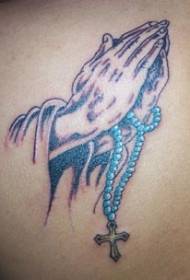 Pregare le mani con il modello del tatuaggio dell'incrocio delle perle blu