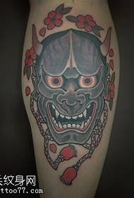 Tatuaggio maschera Prajna sul polpaccio