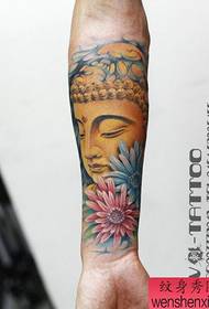 Klasikinė Budos galva su rankomis atremta į gėlių tatuiruotės modelį