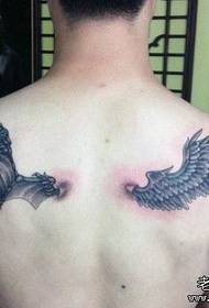 男孩背對一對天使和惡魔之翼的紋身設計