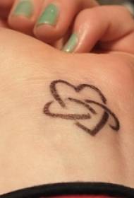Vrouwelijke pols op zwarte lijn creatieve hartvormige schattige tattoo foto