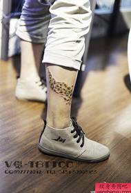 un hermoso patrón de tatuaje de plumas de leopardo popular en la pierna