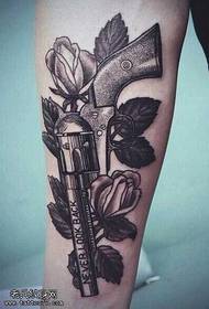 Brazo negro gris pistola flor tatuaje patrón