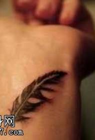 Juodos ir baltos plunksnos tatuiruotės raštas riešo vidinėje pusėje
