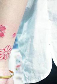 腕の小さな新鮮な花びらの入れ墨のパターンは非常に明るいです