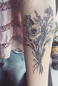 Дзявочая рука на далікатнай расліннай кампазіцыі татуіроўкі малюнка