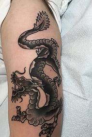 hand op de arm van de prachtige zwarte draakpatroon-tatoeage