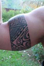 Санскрит татуировкасы үлгісіндегі ер адамның қолындағы қара сақина