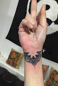 un brazo pequeno cunha tatuaxe tótem