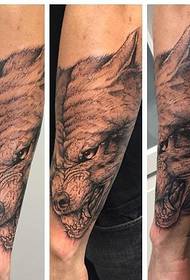 ръка върху жестокия модел на татуировка на главата на вълк