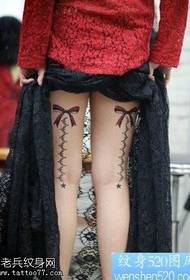 다리에 아름다운 활과 레이스 문신
