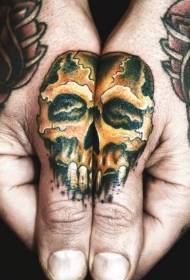 Wzór tatuażu złotej czaszki na palcu