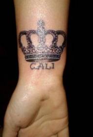 Taji na tattoo ya barua kwenye mkono