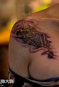Na ramenu zlatni ključ uzorak tetovaže