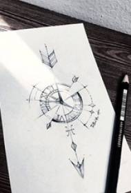 Swart en grys skets wat 'n kreatief verfynde kompas-pyltatoeëring manuskrip uitbeeld