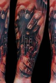 Brațul sfâșiend stilul pielii de mână sângeroasă colorată cu tatuaj de chitară