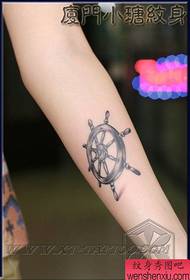 Girl arm met 'n swart en wit roer tattoo patroon