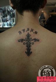 Een klein zwart-wit kruis tattoo-patroon op de rug
