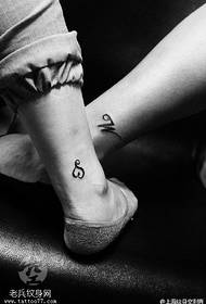 Dashuria me shkronjën tatuazh në kyçin e këmbës